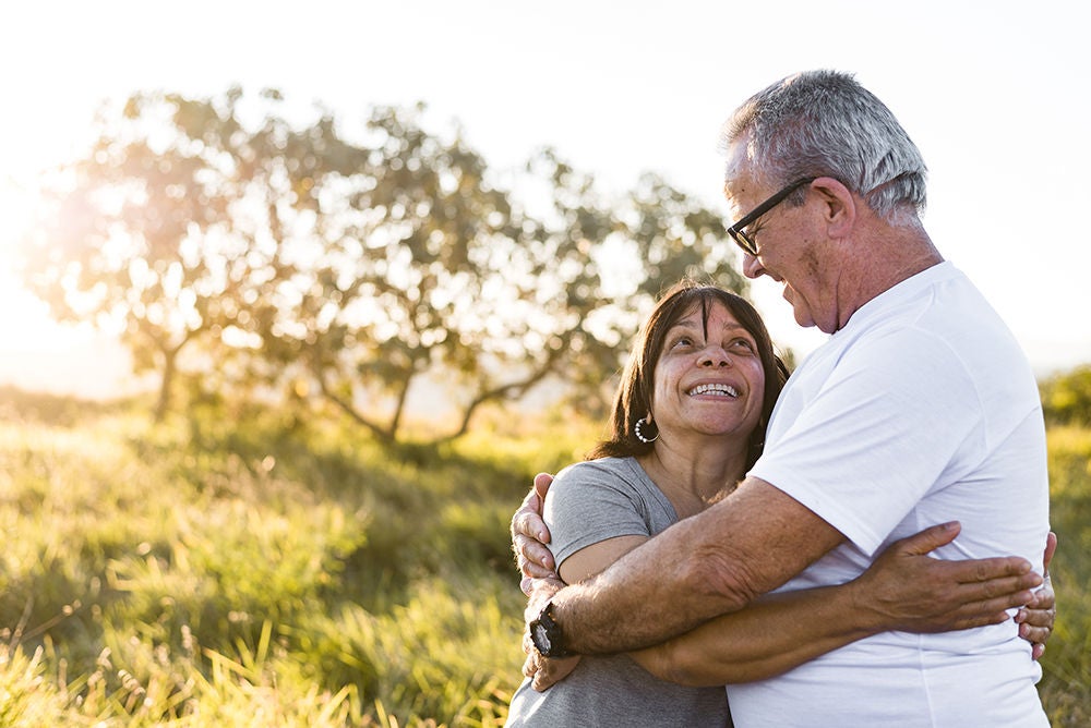 Senior couple smiling at each other while enjoying leisure time outdoors.