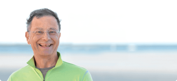 Neil standing on a beach smiling.