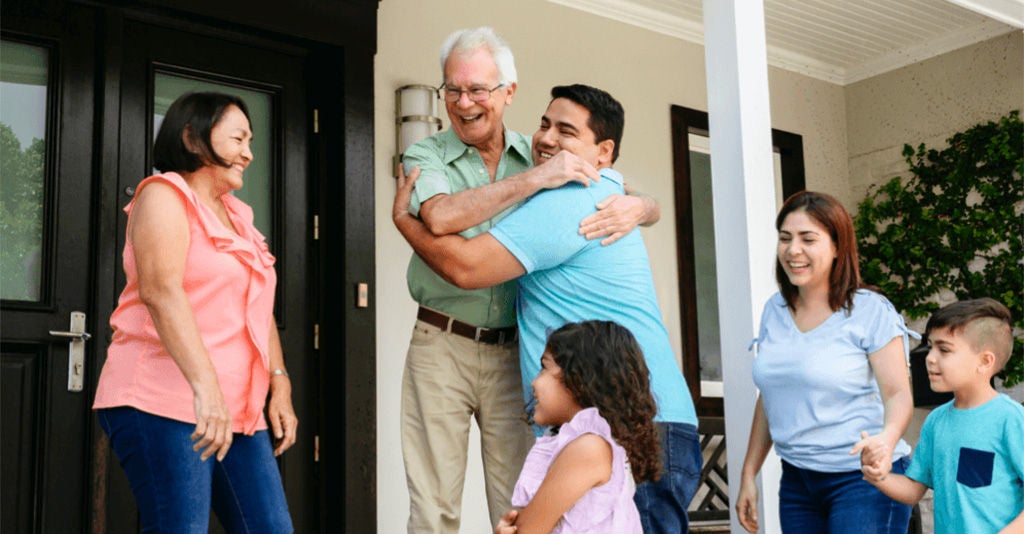 A large family happily reuniting in front of the door.