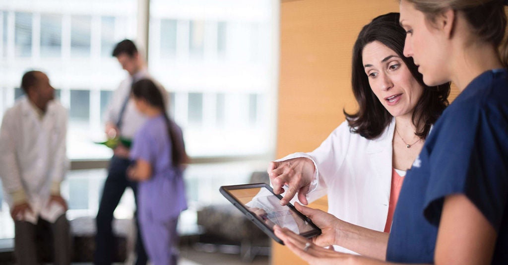 Two pain specialists discussing treatment options in a clinical setting.