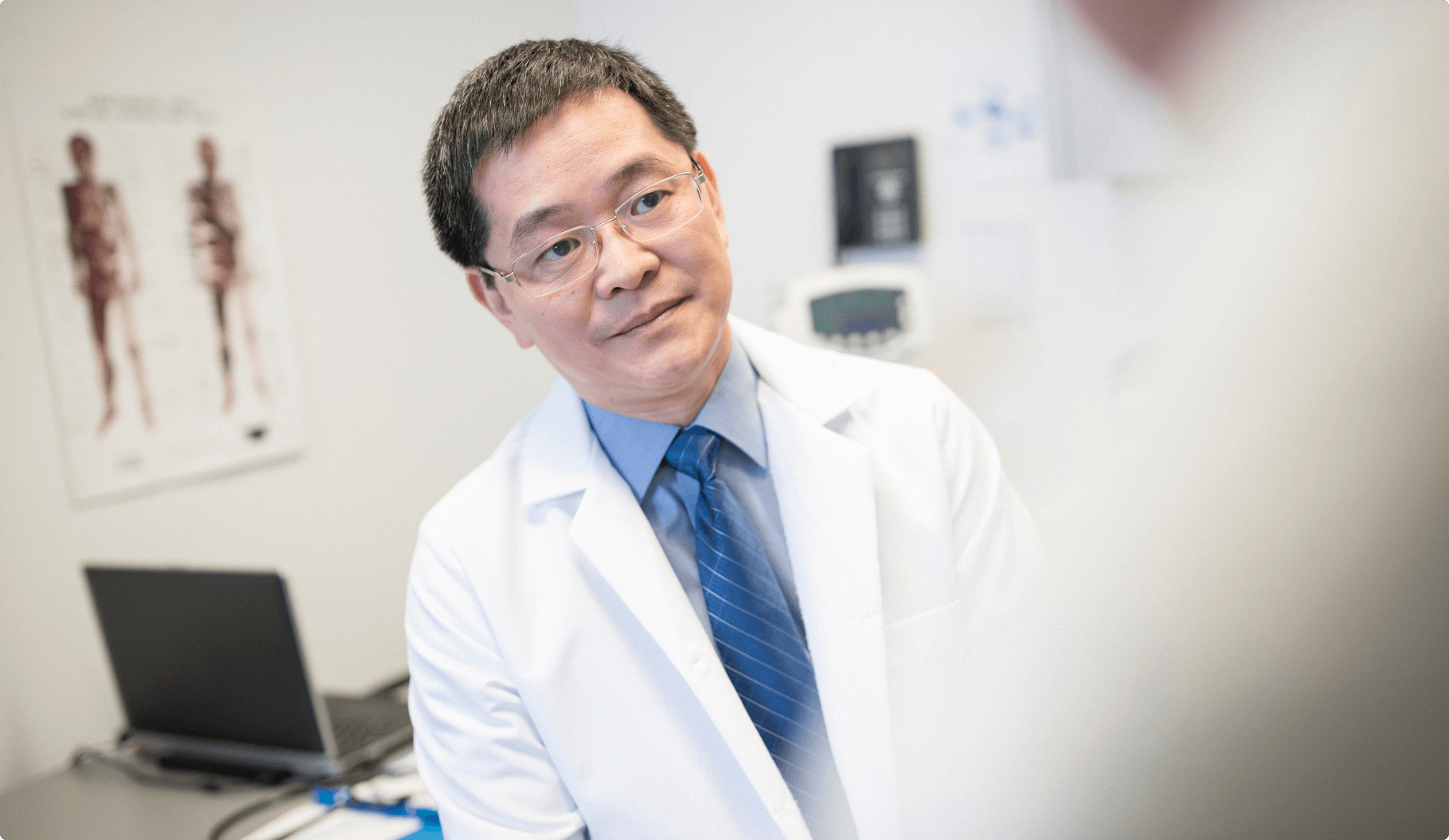 A doctor actively listening during a conversation with a patient in his consultation room.