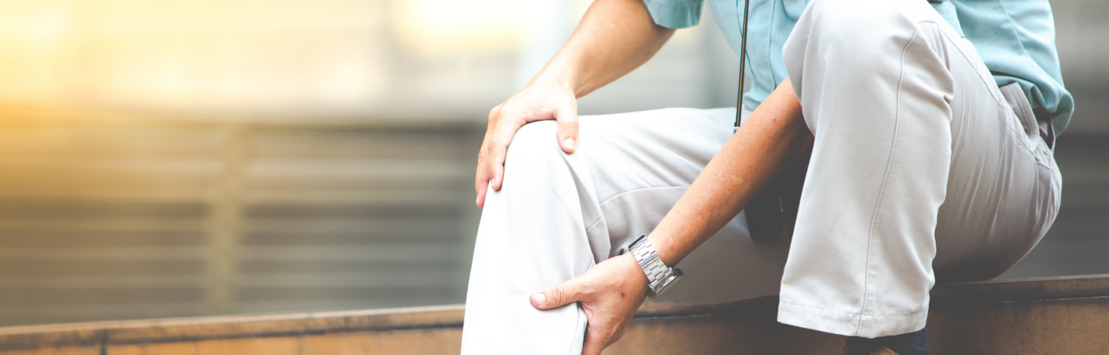 Man experiencing severe leg pain, holding the painful area at his knee and calf.