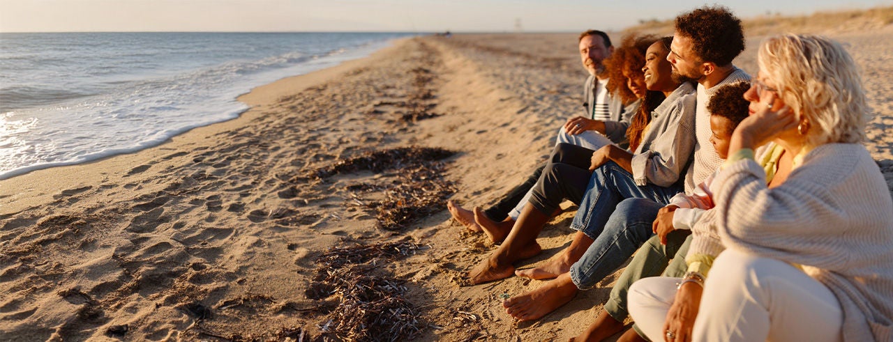 Little boy and teen girl having a fun day at the beach with their families.