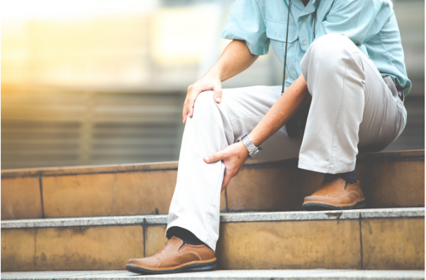 Man experiencing severe leg pain, holding the painful area at his knee and calf.