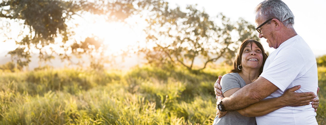 Senior couple smiling at each other while enjoying leisure time outdoors.