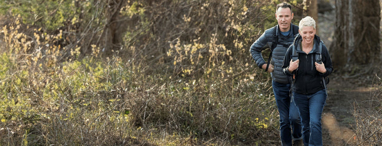 Two people enjoying a happy walk outdoors in the countryside.