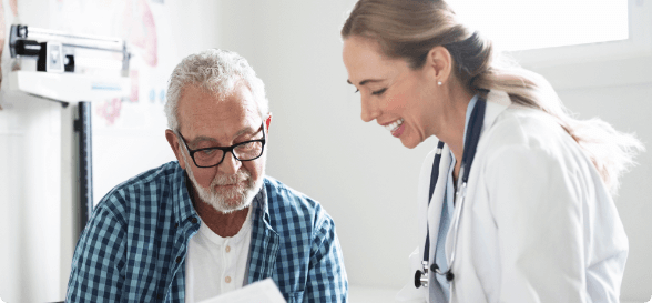 A doctor showing a patient information on a computer screen in an exam room.