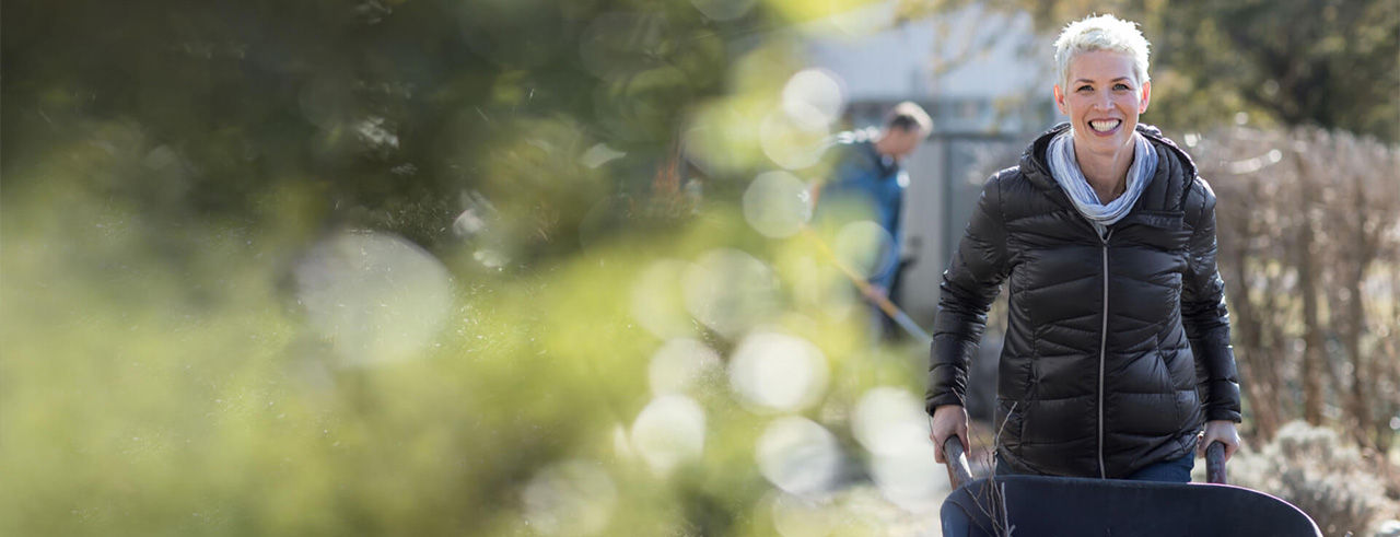 Smiling woman looking at the camera while doing outdoor work.