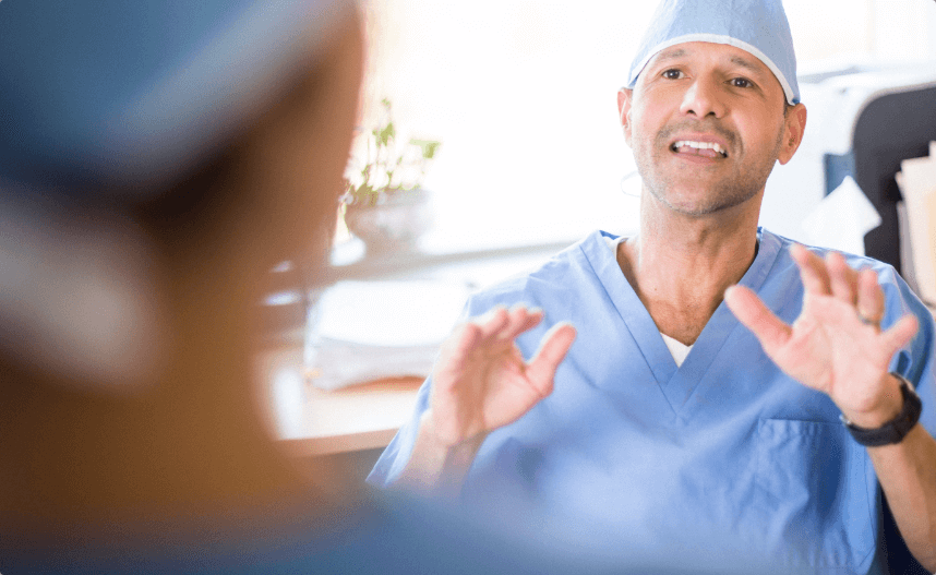 A pain doctor discussing treatment options with his colleague in the operating room.